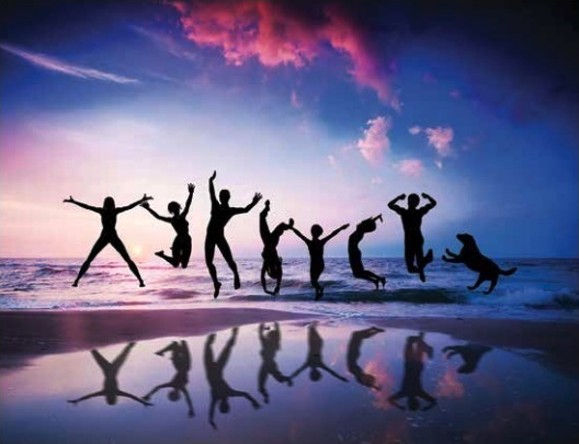 silhouettes of group of people jumping on the beach with blue and purple sunset in the background